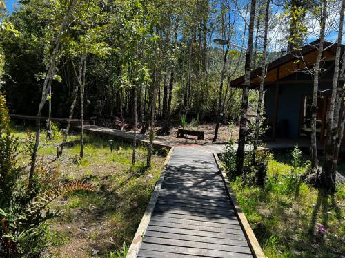 a wooden path leading to a cabin in the woods at Panigal in Hornopiren