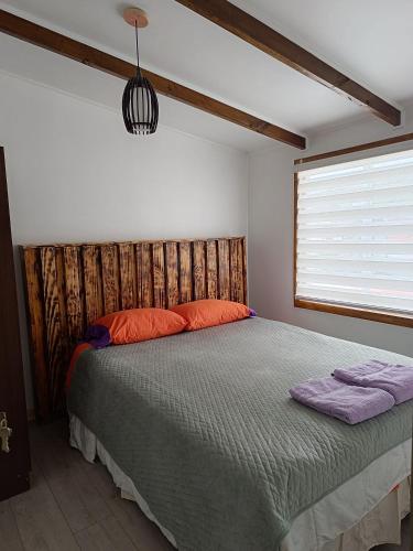 um quarto com uma cama e uma janela em Puerta Archipiélago em Ancud