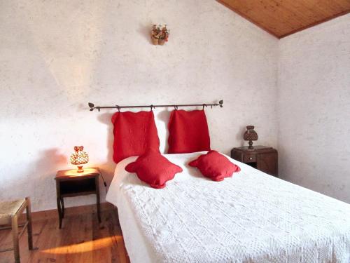 une chambre avec un lit blanc avec des oreillers rouges dans l'établissement Maison accueillante avec vue sur le lac à Moncoutant, à Moncoutant