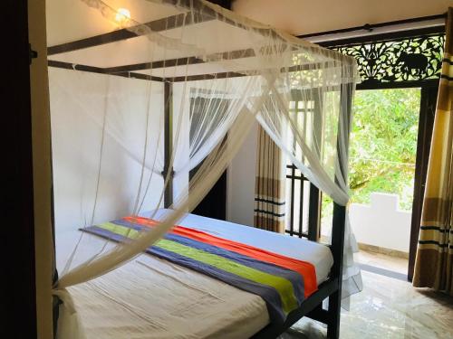 een slaapkamer met een hemelbed bij Villa insy in Galle