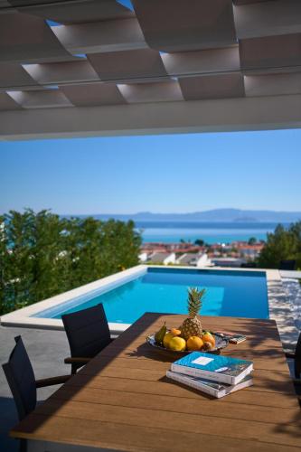 a table with fruit on it next to a swimming pool at Villa Paradisio 2, Pool, Sea View in Hanioti
