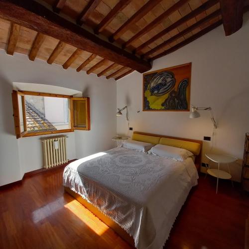 a bedroom with a large bed and a window at Casa Yuri in Poggibonsi