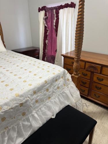 a bedroom with a bed with a wooden dresser and a dresser at Fall River Complete 2 Bedroom Near Downtown in Fall River