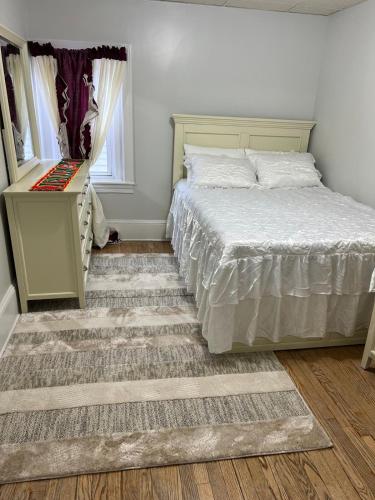 a bedroom with a bed and a dresser and a mirror at Fall River Complete 2 Bedroom Near Downtown in Fall River