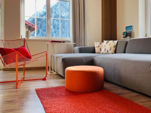 a living room with a couch and a red rug at Dorf(er)leben Ferienwohnung im Kleinwalsertal in Mittelberg