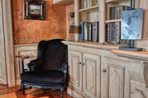 a chair in a room with a book shelf at Le Saint Joseph in Courchevel