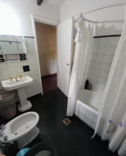 a bathroom with a sink and a tub and a toilet at Los Pinos B&B in Cosquín