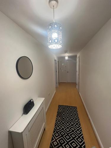 a hallway with a table and a mirror and a light at stylish two bed Ipswich apartment close to the waterfront sleeps 5 perfect for contractors leisure travel stays in Ipswich