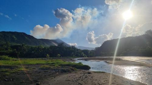 a view of a river with the sun in the sky at Lava view Bungalows in Isaka