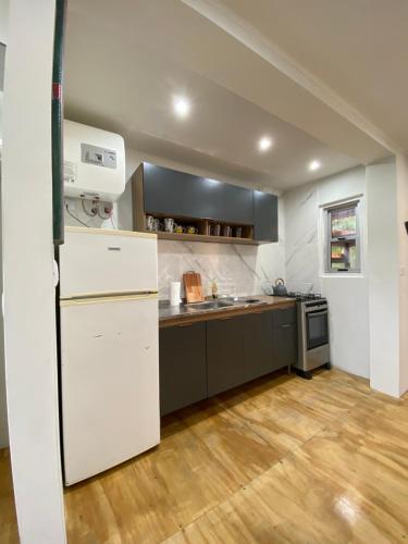a kitchen with a white refrigerator and a wooden floor at Flor de Canela 1 in Punta del Este