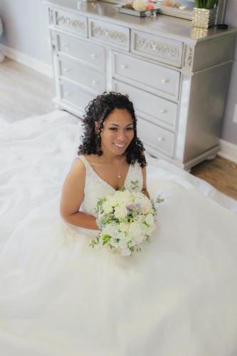 a woman in a white dress holding a bouquet of flowers at Whisper Chateau Weddings Reunions Groups 75 Plus in Greensboro