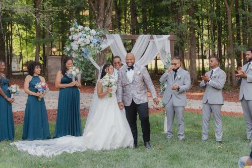 a bride and groom walking down the aisle at their wedding at Whisper Chateau Weddings Reunions Groups 75 Plus in Greensboro