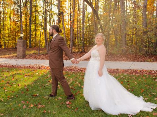 a bride and groom holding hands in the grass at Whisper Chateau Weddings Reunions Groups 75 Plus in Greensboro