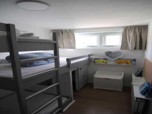 a small bedroom with a bunk bed and a window at Furnished bungalow near beach in Sint Maartenszee