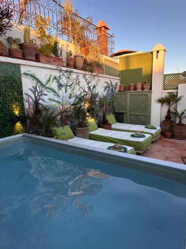 un cortile con piscina e un patio con piante di Riad Dar Adal exclusivité 2 à 6 personnes petit déjeuner compris place jemaa El fna a Marrakech