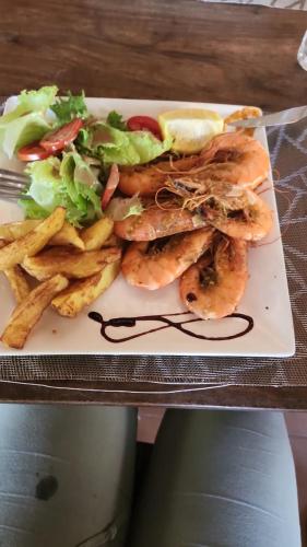 a plate of food with a sandwich and french fries at La Case Sauvage in Diana
