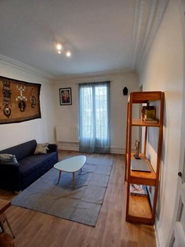 un salon avec un canapé bleu et une table dans l'établissement Detente, à Paris