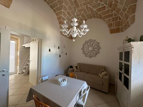 a living room with a table and a chandelier at La terrazza di Lillo in Carovigno