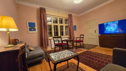 a living room with a tv and a table and chairs at Gemütliche Wohnungen in Wansdorf im denkmalgeschützten Haus in Wansdorf