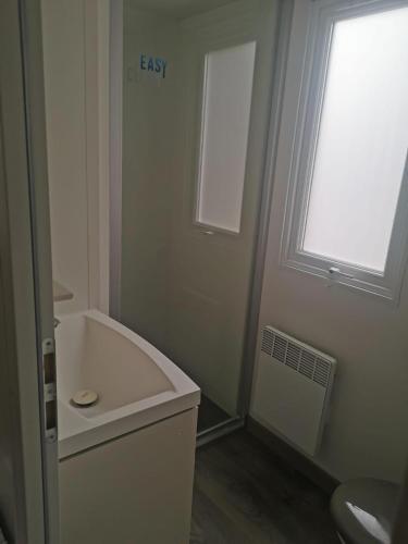 une salle de bain avec une baignoire, un lavabo et une fenêtre dans l'établissement Serenity Bonne Anse, aux Mathes