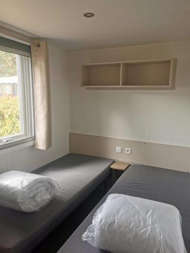 une chambre avec deux lits et une fenêtre dans l'établissement Serenity Bonne Anse, aux Mathes