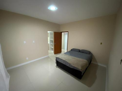 a bedroom with a bed in a white room at Casa Refúgio do Vale *Unimed* in Volta Redonda