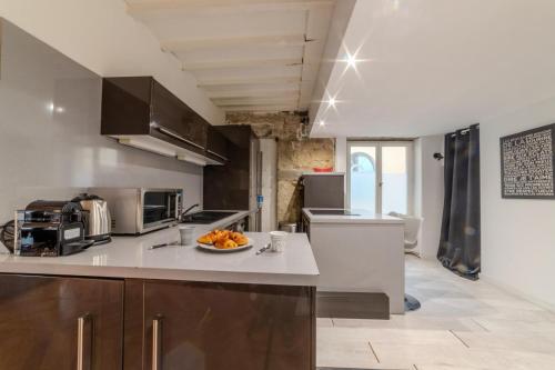 une cuisine avec un bol de fruits sur un comptoir dans l'établissement Magnifique Appartement - Place des Terreaux, à Lyon
