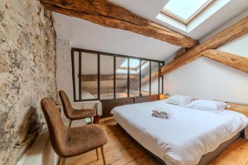 une chambre avec un lit et une chaise dans l'établissement Magnifique Appartement - Place des Terreaux, à Lyon