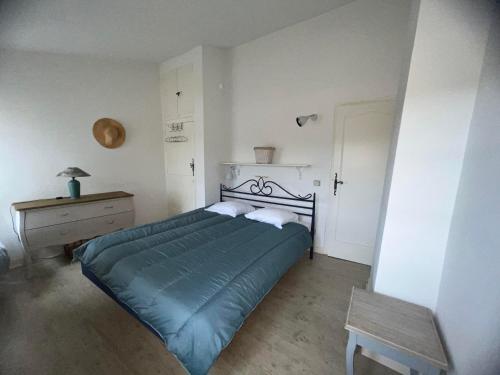 a bedroom with a bed with a green blanket and a table at Maison Provençale in Bauduen