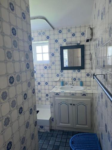 une salle de bain blanche avec un lavabo et un miroir dans l'établissement Maison Provençale, à Bauduen