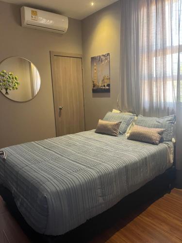 a bedroom with a bed with a blue and white comforter at Royal Suites Amoblados in Galapa