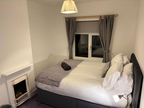 a bed in a room with a window and a bed sidx sidx sidx at Cosy 2-bed NR New Cross Hospital in Wednesfield