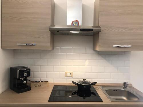 a kitchen with a sink and a pot on the stove at Le Antiche Alcove in Terrasini