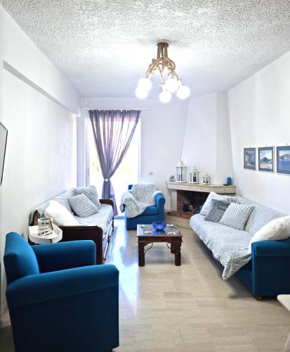a living room with blue chairs and a couch at Gentle Breeze apartment in Kamena Vourla