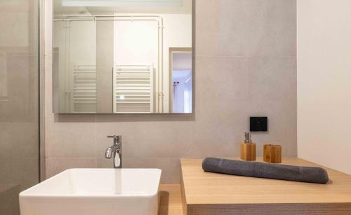 une salle de bain avec un lavabo blanc et un miroir dans l'établissement La Flanerie Pedestrian Street Annecy, à Annecy