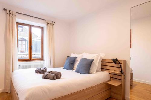 une chambre avec un grand lit avec des serviettes dessus dans l'établissement La Flanerie Pedestrian Street Annecy, à Annecy