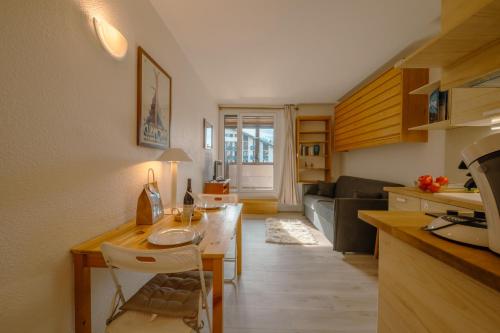 une cuisine et un salon avec une table et un canapé dans l'établissement Chamonix Sud - Genevrier 104 - Happy Rentals, à Chamonix-Mont-Blanc