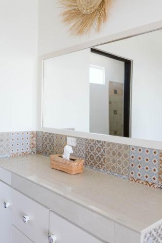 a bathroom counter with a mirror and a sink at Olas de Cerritos in El Pescadero