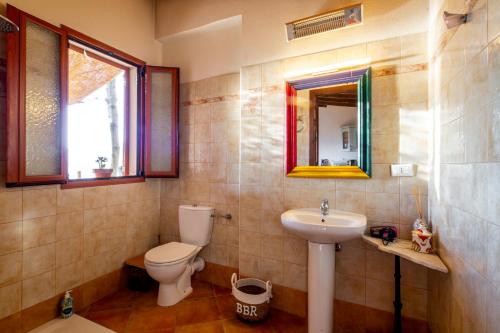 un bagno con un water, un lavandino e uno specchio di Sicilian pool chalet a Ventimiglia