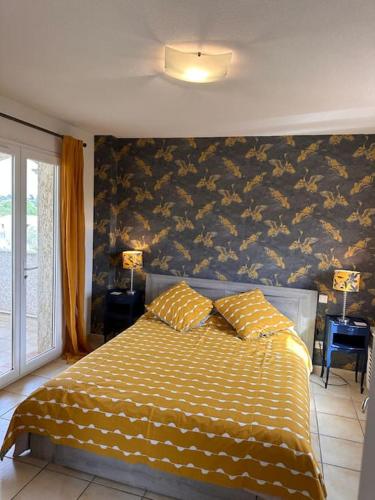 a bedroom with a bed with a yellow and white comforter at Village villa, private pool, canal du midi in Argens Minervois