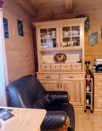 a leather chair in a kitchen with a cabinet at Siedlisko Sielska Dolina Nad Stawem luksusowy domek całoroczny z klimatyzacją in Tarnowiec