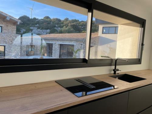 une cuisine avec un évier et une grande fenêtre dans l'établissement Le Mas du Mas d' Antonegre, à Montbazin