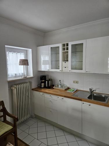 a kitchen with white cabinets and a sink at Haus Sibylle in Bad Tölz