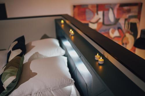 Cette chambre comprend 2 lits avec des oreillers blancs et un tableau. dans l'établissement Gîte Nuit Féline, à Cirière