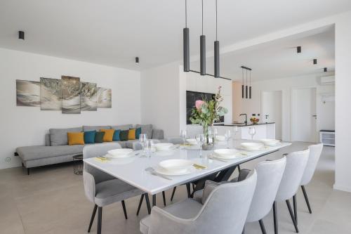 a white dining room with a white table and chairs at Villa Magic Sky II in Kraj