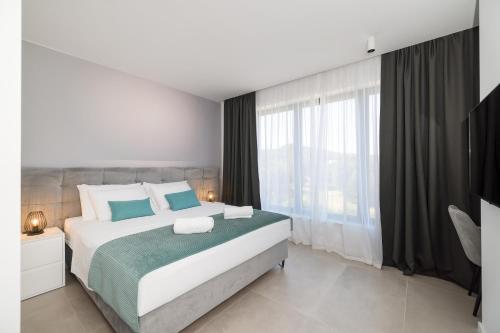 a bedroom with a large bed and a large window at Villa Magic Sky II in Kraj