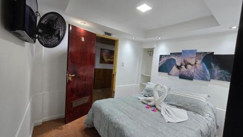 a bedroom with a bed and a wall with paintings at Hotel y Restaurant AKATA in Río Mayo