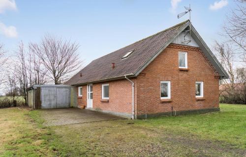 an old brick house with a garage in a yard at Awesome Home In Øster Assels With Wifi in Øster Assels