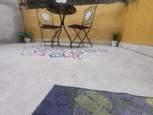 two chairs and a table on a floor with a rug at Casetta sul mare in Savona