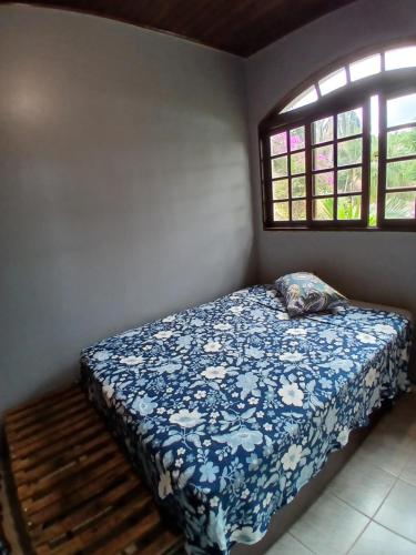 a bedroom with a bed with a blue and white blanket at Chácara casa da sogra in Santana de Parnaíba